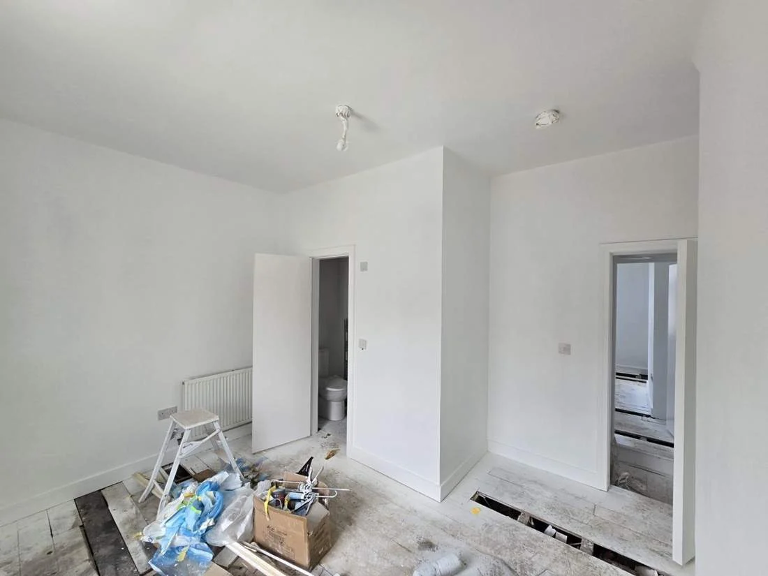 New build spraying project with white walls, ceilings, doors and skirting during work